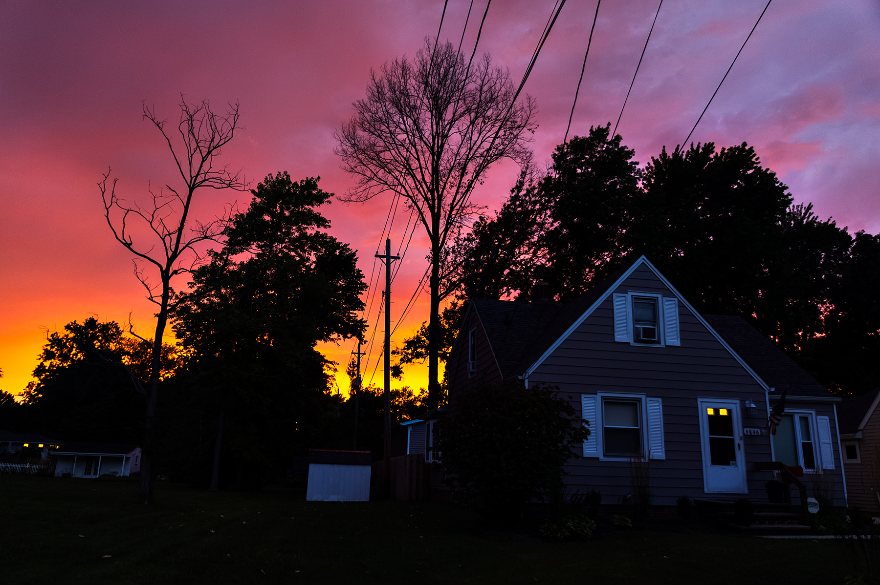 Suburban home silhouetted against extraordinary purple and orange sunset sky, Willoughby Ohio